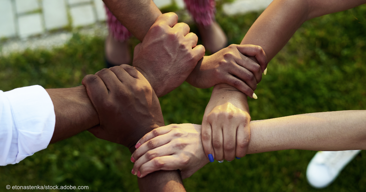 Eine Nahaufnahme von fünf Händen, die sich gegenseitig festhalten