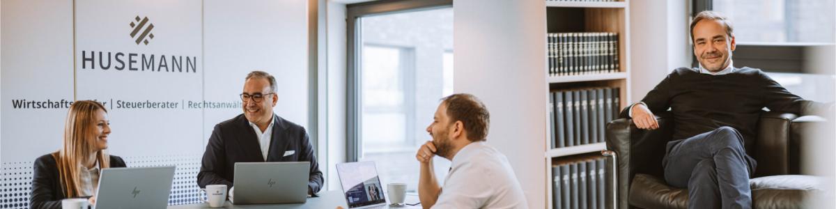 Links sitzt ein Team von Rechtsanwälten und bespricht gemeinsam Mandate im modernen Besprechungsraum einer Wirtschaftskanzlei, mit Laptops und Unterlagen am Tisch. Rechts sitzt ein Partner der Kanzlei im Büro mit Bücherregal im Hintergrund.